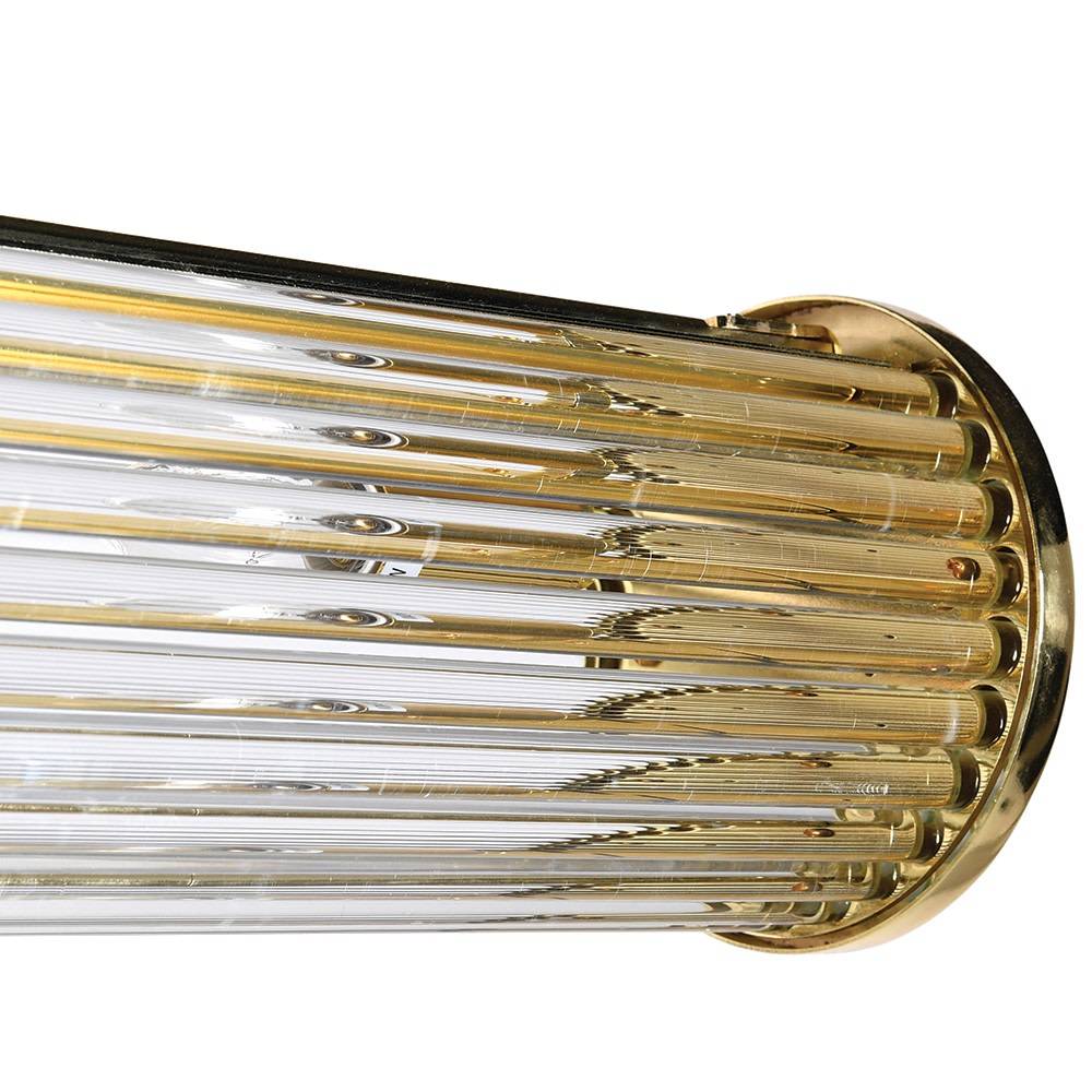 Long glass tubular, linear light, set on two gilt bars and a gilt coloured roof plate. The ends of the long bar are enclosed by two round gilt discs. Great Island light.
