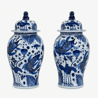Pair of medium blue and white glazed ginger jars decorated with fish, aquatic plants and floral motifs, each with a domed lid and blue guardian-lion finial.