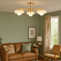 Mid-century style three globe ceiling light with brushed gilt metal frame and opal glass shades in a living room