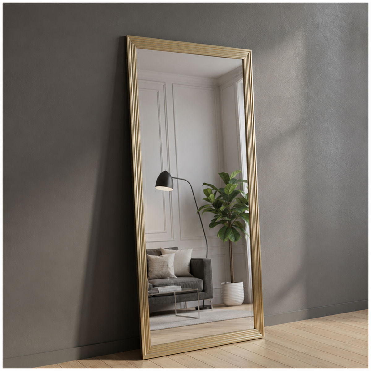 Gold-framed mirror leaning against a gray wall with a living room reflection.