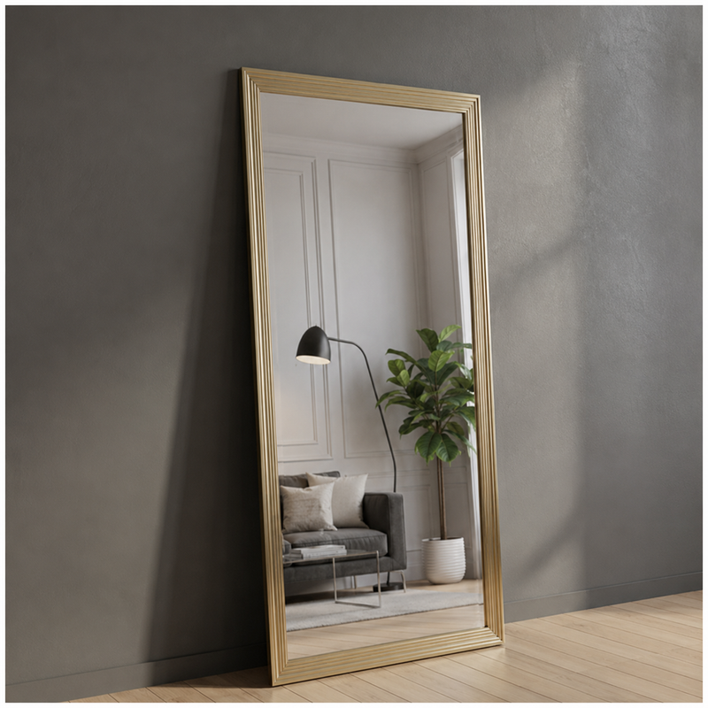 Gold-framed mirror leaning against a gray wall with a living room reflection.