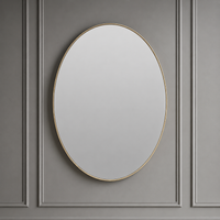 Round mirror with a gold frame on a gray paneled wall