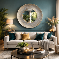 Moroccan mirror on wall in a teal coloured room over a sofa with a coffee table and accessories. 