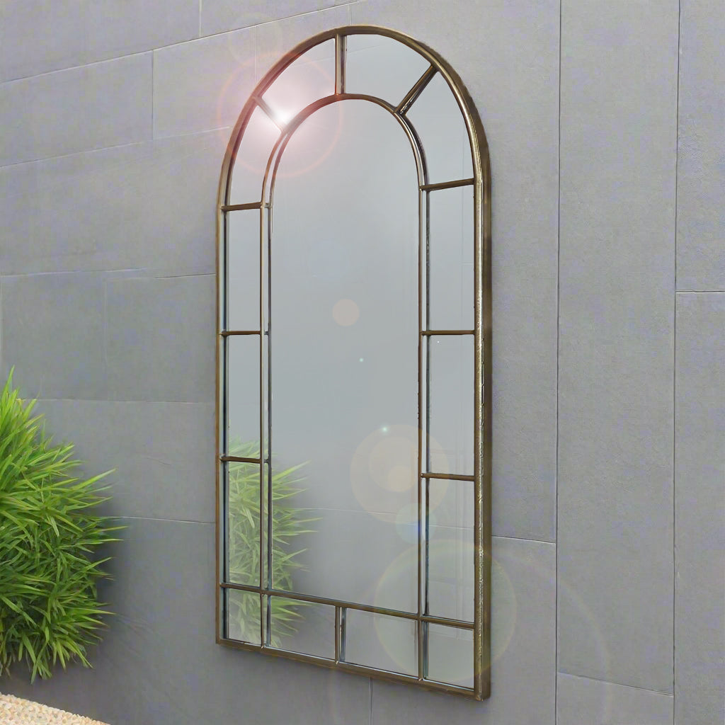 Arched window mirror on a grey outdoor wall