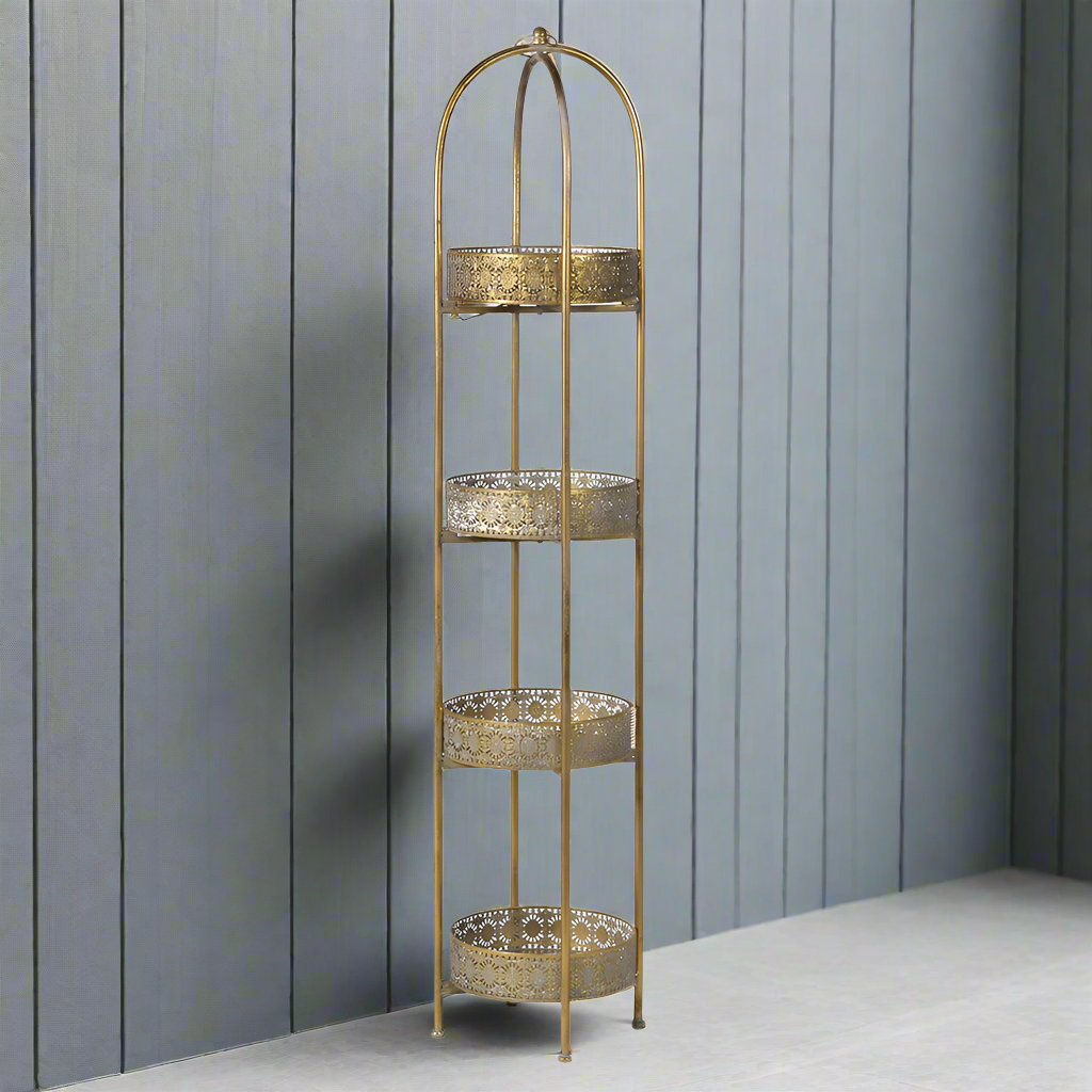 A unique and very pretty shelf unit with pierced metal detailing around shelves that can be lifted out and also used as trays. Finished in a rustic antique gold, this furniture piece has Moroccan vibes with five shelves encased in an outer frame that can fold flat. 