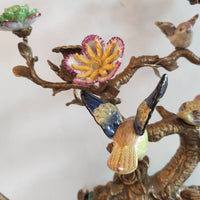 Decorative jewelry set with birds and flowers on a branch against a white background