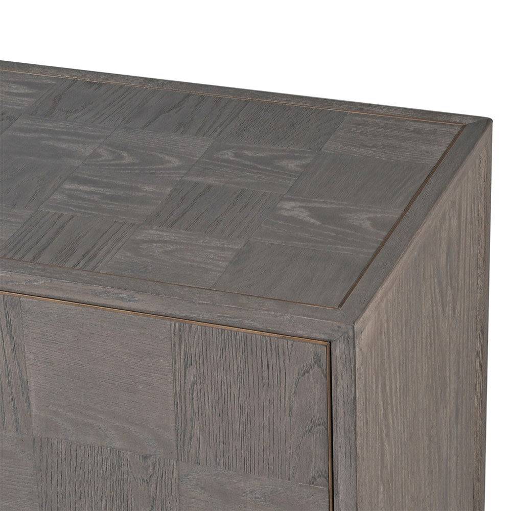A sleek, contemporary long sideboard in a pale grey finish. This sideboard has four doors and has a particular stylish set of handles to the door in a dark gilt finish. There is a pattern of squares in the wooden surface of this piece. The sidebaord has four doors and two shelves behind each door, which provides ample 