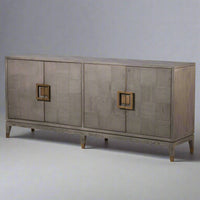 A sleek, contemporary long sideboard in a pale grey finish.&nbsp; This sideboard has four doors and has a particular stylish set of handles to the door in a dark gilt finish.&nbsp; There is a pattern of squares in the wooden surface of this piece. The sidebaord has four doors and two shelves behind each door, which provides ample storage.&nbsp; Perfect contemporary piece for your dining or living room, the colour of this sideboard would work well in a contemporary setting.