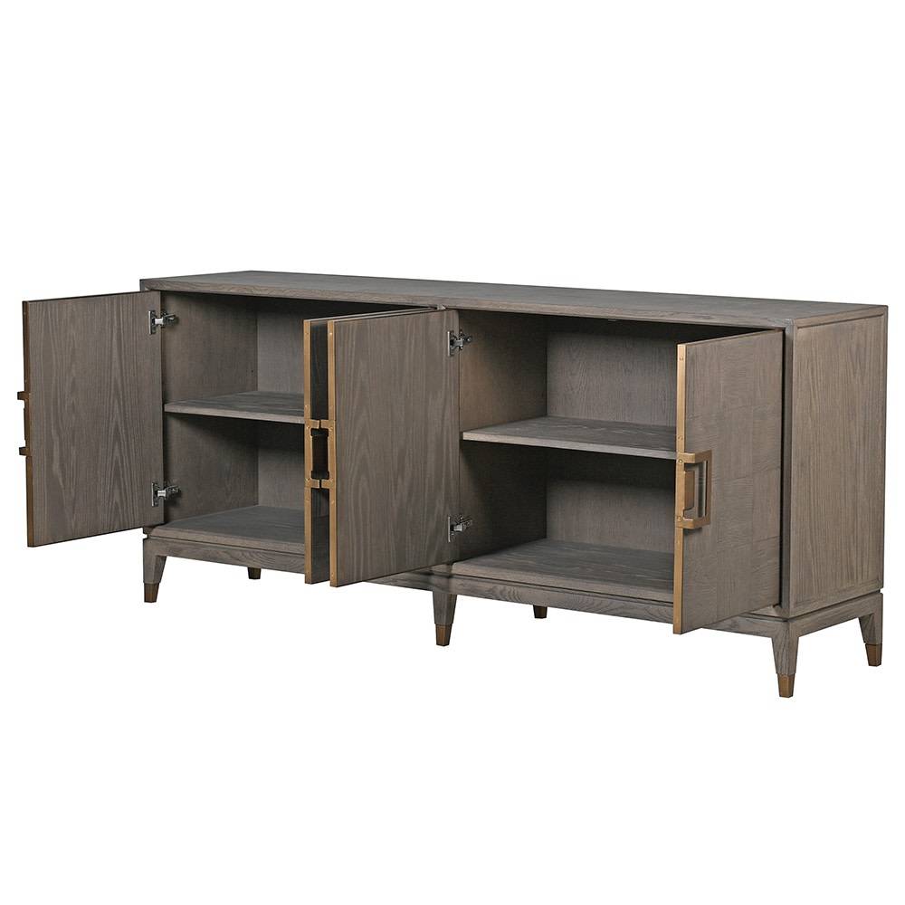 A sleek, contemporary long sideboard in a pale grey finish. This sideboard has four doors and has a particular stylish set of handles to the door in a dark gilt finish. There is a pattern of squares in the wooden surface of this piece. The sidebaord has four doors and two shelves behind each door, which provides ample 