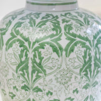 Detail of floral pattern on olive green, ceramic table lamp.