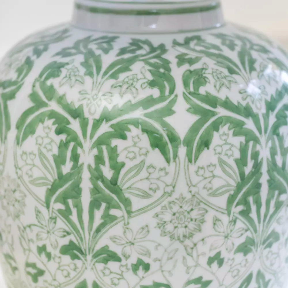 Detail of floral pattern on olive green, ceramic table lamp.