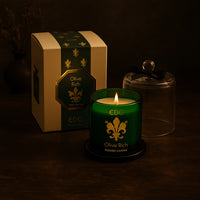 Olive Rich luxury scented candle in green glass with gold detailing and a clear cloche, presented with a matching gift box.