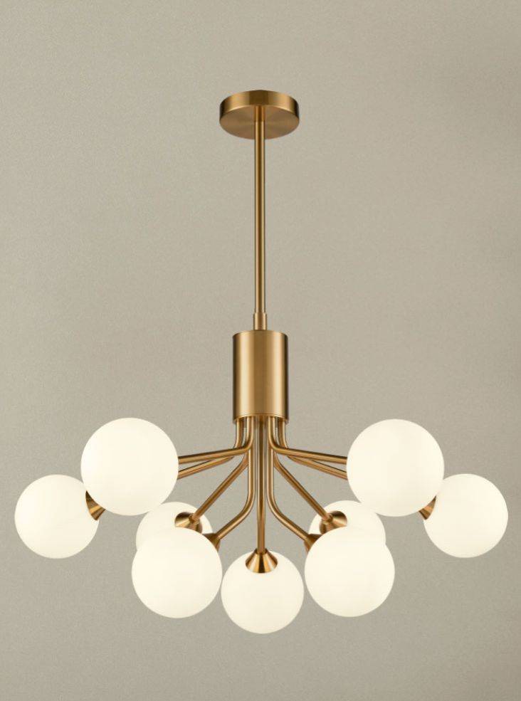 Opaque globe 9 ball chandelier with brushed brass arms and opal glass shades hanging from an adjustable rod