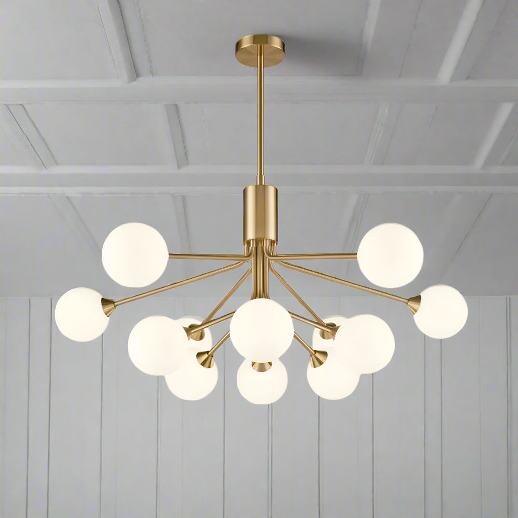 Twelve light opaque glass globe ceiling pendant in brushed brass finish