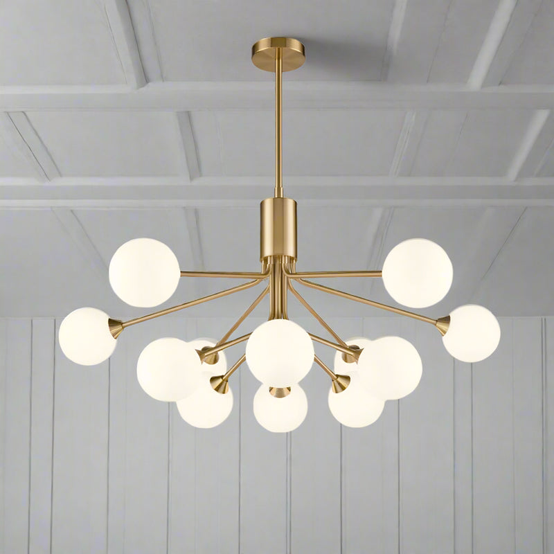 Twelve light opaque glass globe ceiling pendant in brushed brass finish