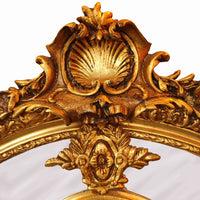Ornate gilded mirror frame with cherub accents and intricate floral carvings