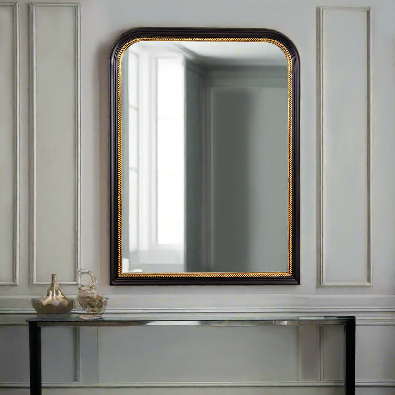 Black arched mirror in hallway above a cpnte,porary console table