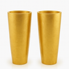 Pair of tall oversized gilt vases with tapered cylindrical shape and textured gold finish.