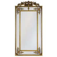 Tall, elegant paneled mirror in gilt wood frame with baroque motifs to the corners.