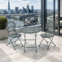 Three piece bistro set, folding grey metal table and two chairs, on a city balcony.