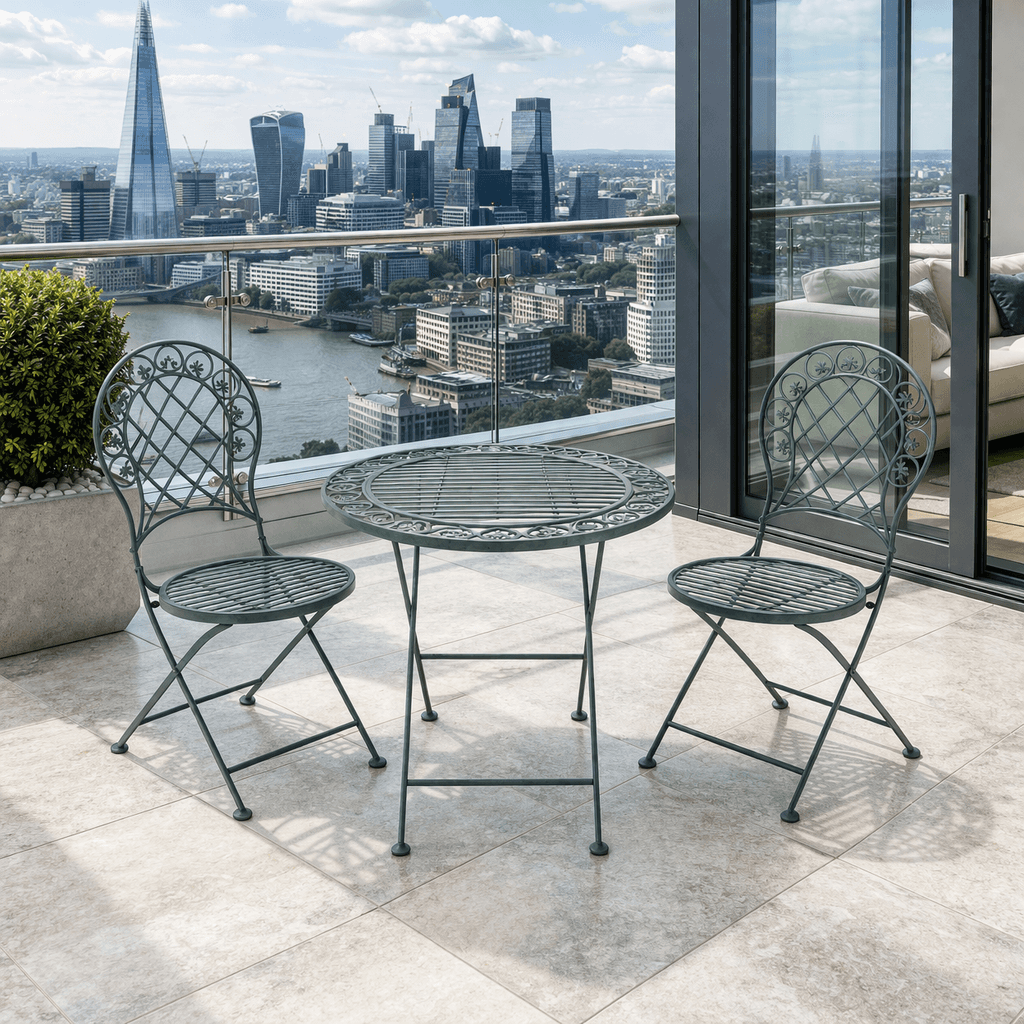Three piece bistro set, folding grey metal table and two chairs, on a city balcony.