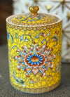 Handcrafted yellow ceramic scented candle jar with gold detailing and floral design, scented with Pineapple and Coconut.