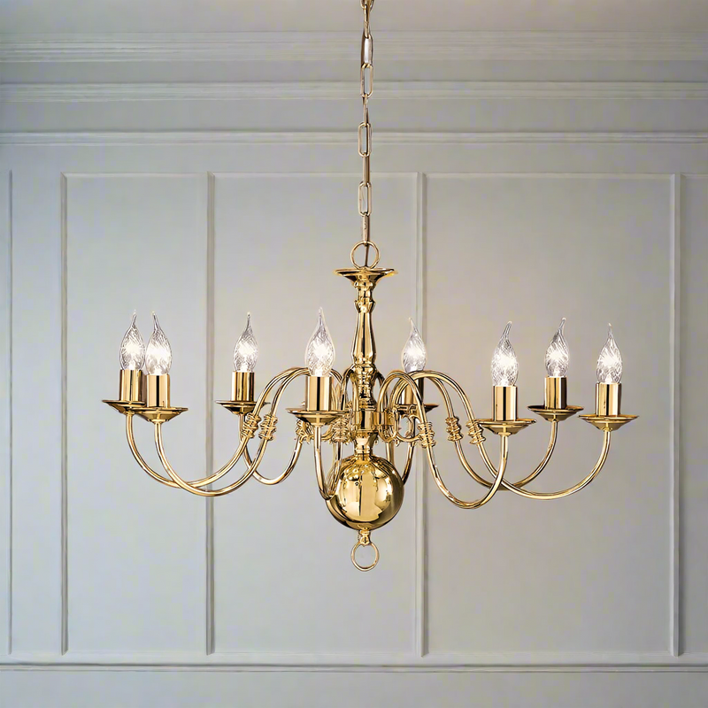 A polished brass eight-arm chandelier with a classic design, hanging against a neutral background.