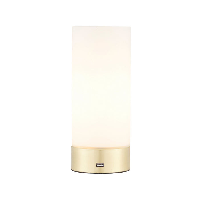 A cylindrical portable table lamp with a milk glass in a sleek brushed brass metal base. It has an USB port to charge any devices and a three touch dimmer settings.