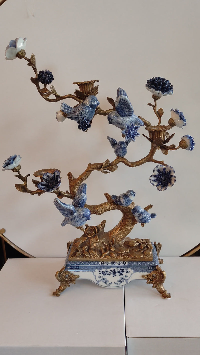 Blue and white porcelain bird tree sculpture with gold accents on decorative base