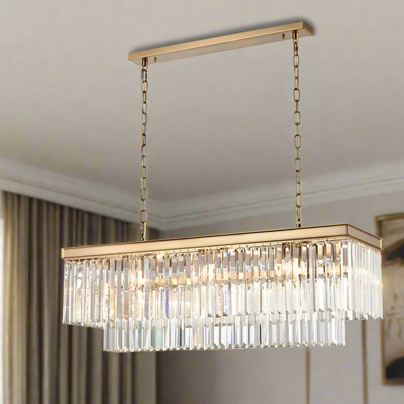 A luxurious rectangular crystal prism chandelier with gold metal detailing, hanging by chains.