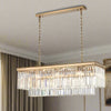 A luxurious rectangular crystal prism chandelier with gold metal detailing, hanging by chains.