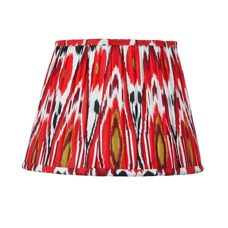 Red pleated cotton lampshade with bold Ikat pattern in red, white and gold tones.