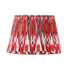 Red pleated cotton lampshade with bold Ikat pattern in red, white and gold tones.