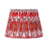 Red pleated cotton lampshade with bold Ikat pattern in red, white and gold tones.