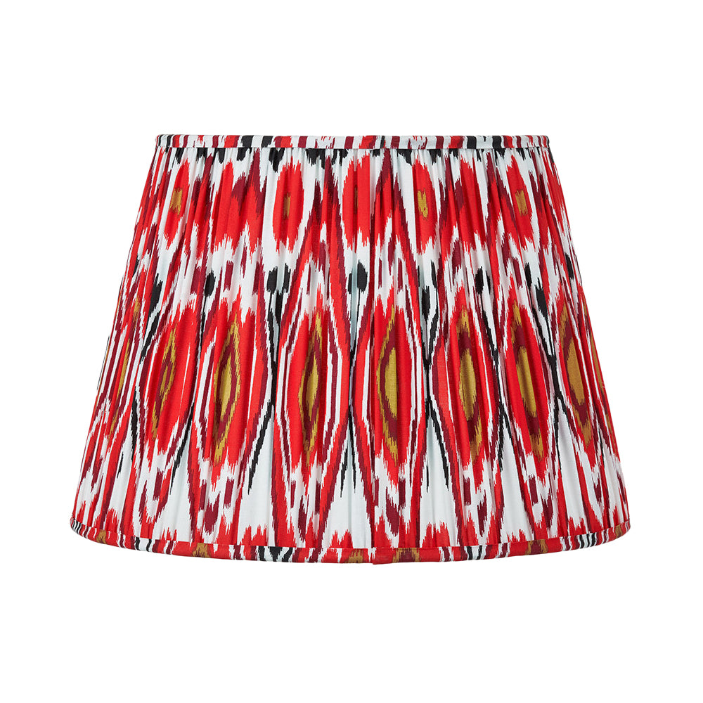 Red pleated cotton lampshade with bold Ikat pattern in red, white and gold tones.