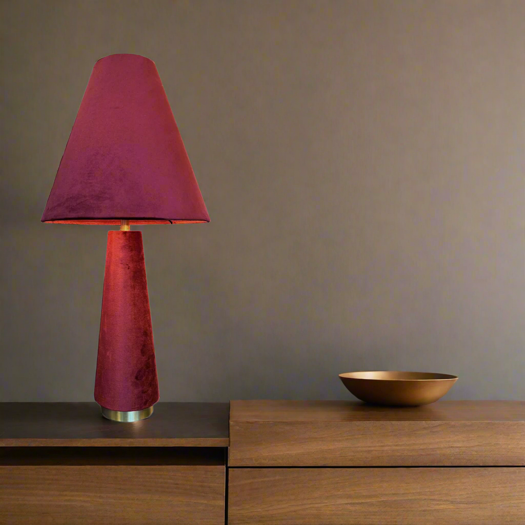A stunning red velvet lamp and shade, an unusual but very tactile lamp made entirely of red velvet fabric.&nbsp; Perfect bedside lamp, the conical shade is placed onto an inverted conical base connected by an antique brass rod and antique brass base. The perfect way to add colour to a room, a pair of these vibrant lamps will create a warm glow to any interior.