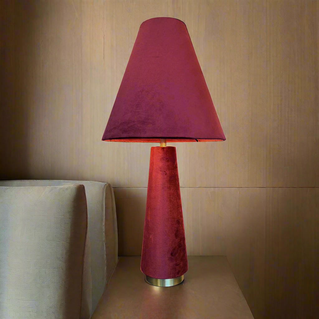 A stunning red velvet lamp and shade, an unusual but very tactile lamp made entirely of red velvet fabric.&nbsp; Perfect bedside lamp, the conical shade is placed onto an inverted conical base connected by an antique brass rod and antique brass base. The perfect way to add colour to a room, a pair of these vibrant lamps will create a warm glow to any interior.