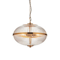 This elegant globe pendant light features a ribbed glass shade with a warm brass finish, blending vintage charm with modern appeal. 