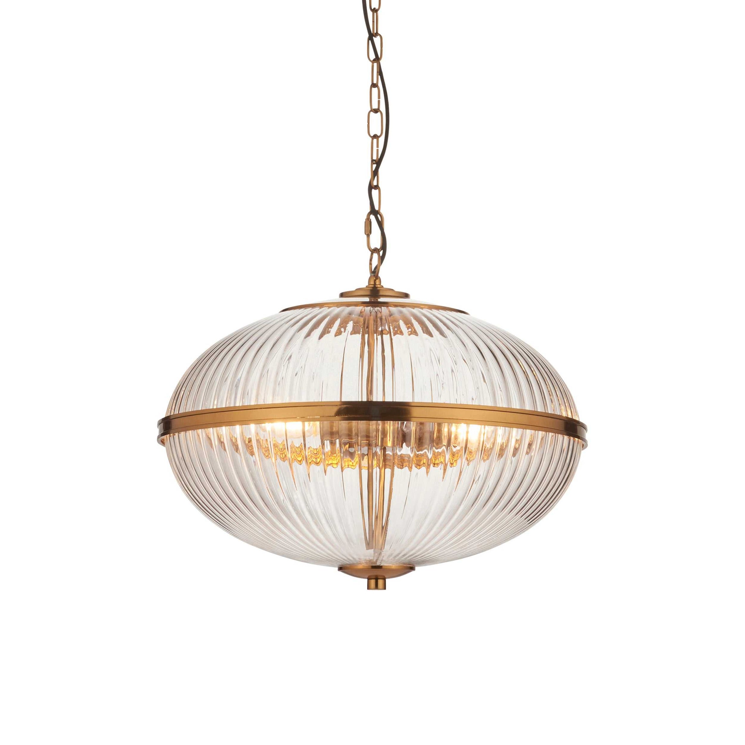 This elegant globe pendant light features a ribbed glass shade with a warm brass finish, blending vintage charm with modern appeal. 