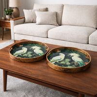 Two decorative exotic bird trays on a mid-century style table in a living room setting