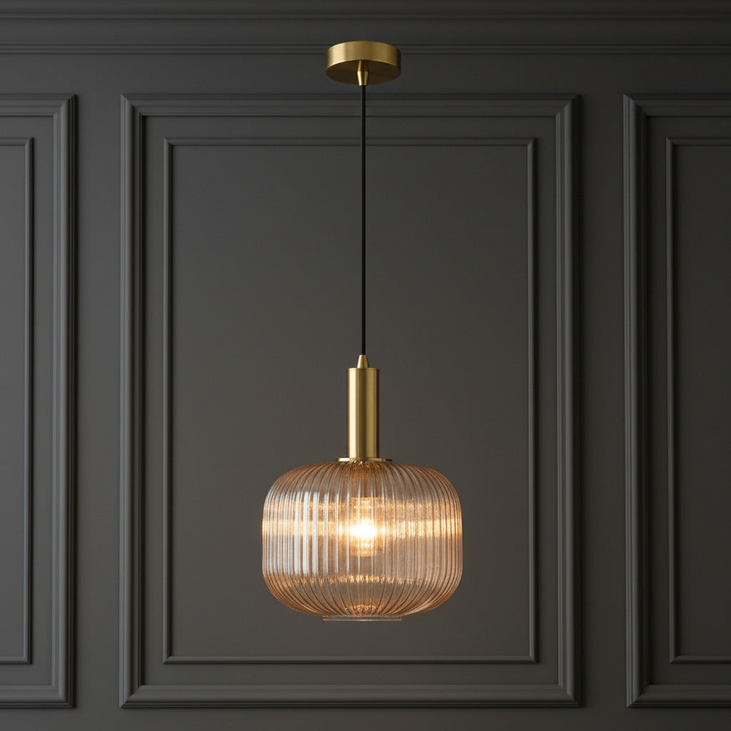 Modern pendant light with gold fixture and ribbed glass shade on a white background