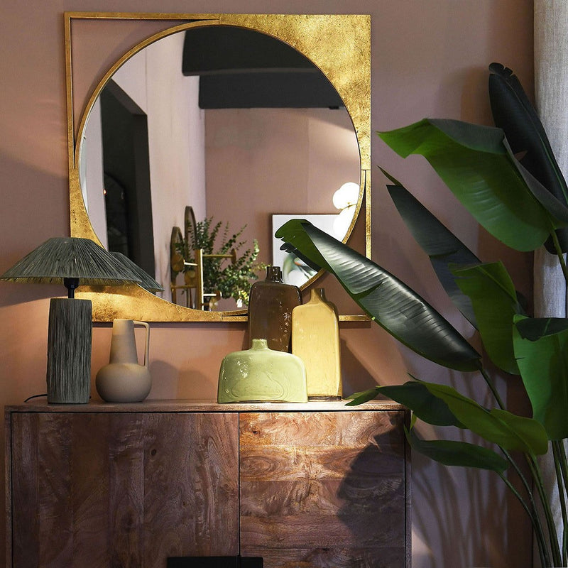 This circular mirror is framed in a gold metal frame in an original way.