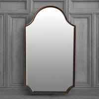 Bronze mirror on a grey paneled wall.