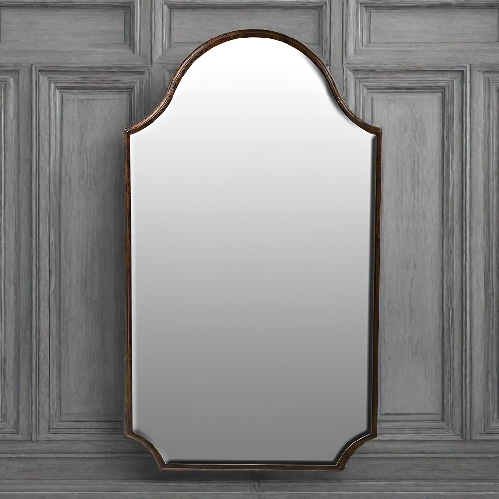 Bronze mirror on a grey paneled wall.