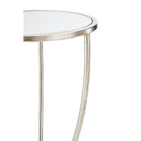 Silver round side table with mirrored top and curved metal legs.