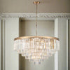 This six-tier crystal chandelier is designed to make a bold, unforgettable statement in any room. Its polished gold band supports cascading layers of prism-cut crystals