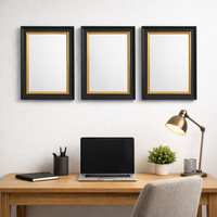 Three black and gold mirrors grouped in a home office above a desk in a modern setting.