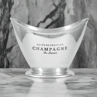 A clear, sloped champagne cooler with cut-out handles and a vintage champagne logo across the front, placed on a marble surface.