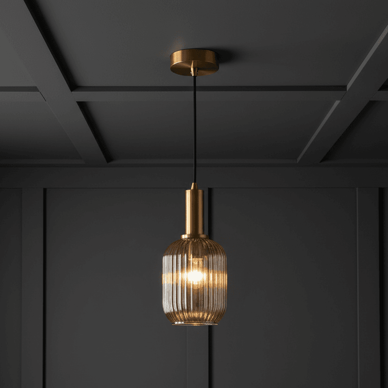 Smoked glass and gilt metal fitting in a grey paneled room.