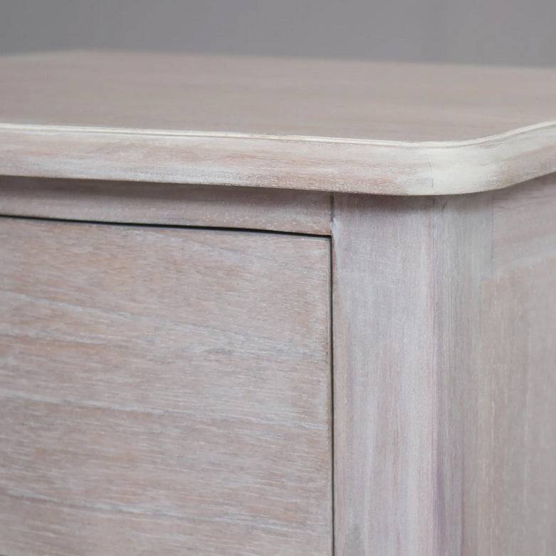 A solid hardwood three draw bedside table made from bleached mahogeny wood with ash veneers in a white wash finish. 